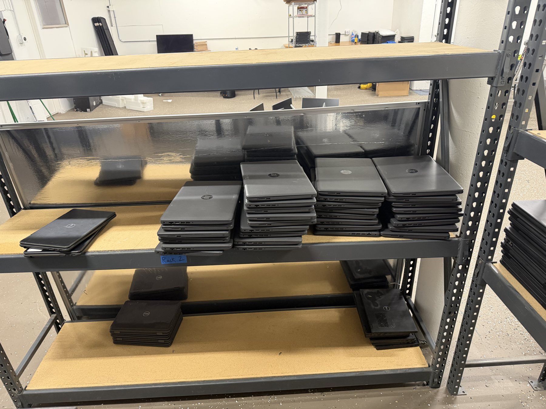 Used laptops arranged on shelving in the GRT workspace